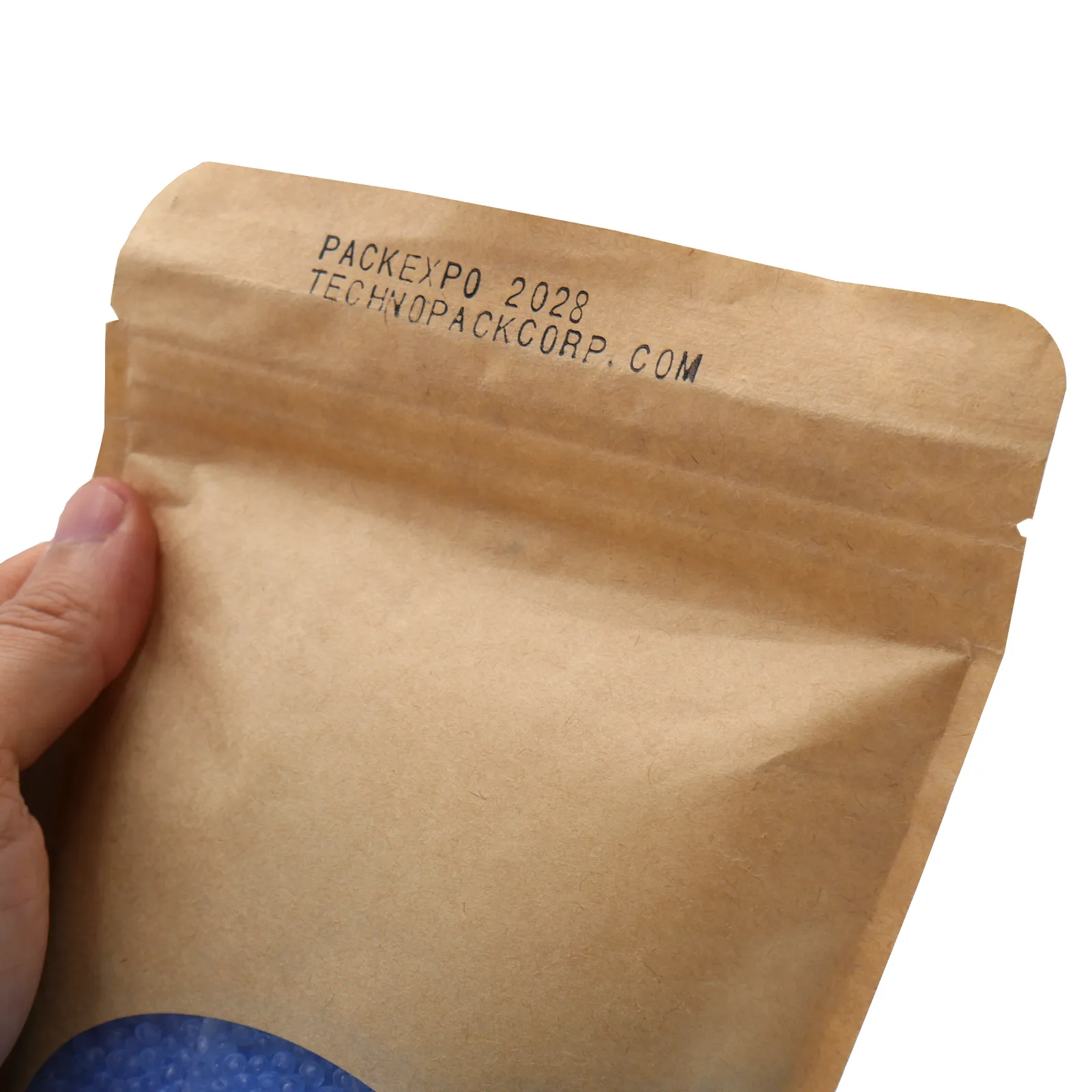 Operador sosteniendo una bolsa marrón sellada e impresa con fecha por el codificador de estampado en caliente de la selladora horizontal continua de banda JORES TECHNOLOGIES®