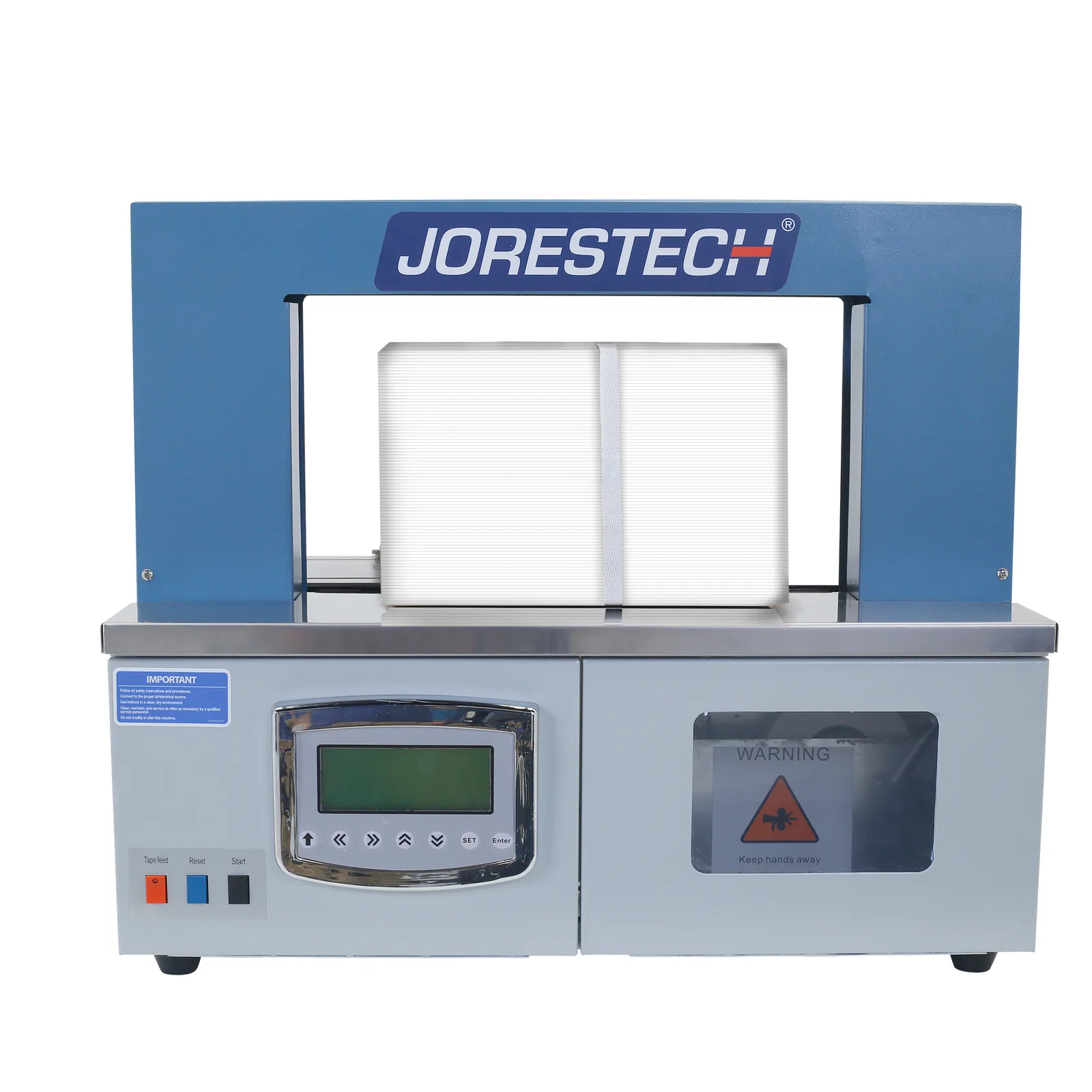 Vista frontal de una máquina de flejado JORES TECHNOLOGIES® ® gris y azul para papel y plástico. Se puede ver una caja blanca en el área de sellado con una banda blanca alrededor.