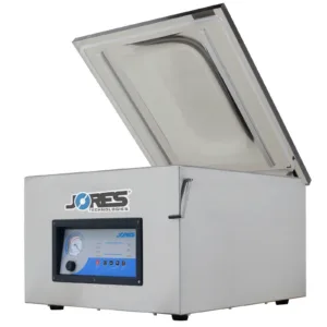 Lado de la selladora al vacío comercial de una sola cámara de sobremesa JORES TECHNOLOGIES® de acero inoxidable con doble barra de sellado. La máquina de vacío tiene la tapa abierta