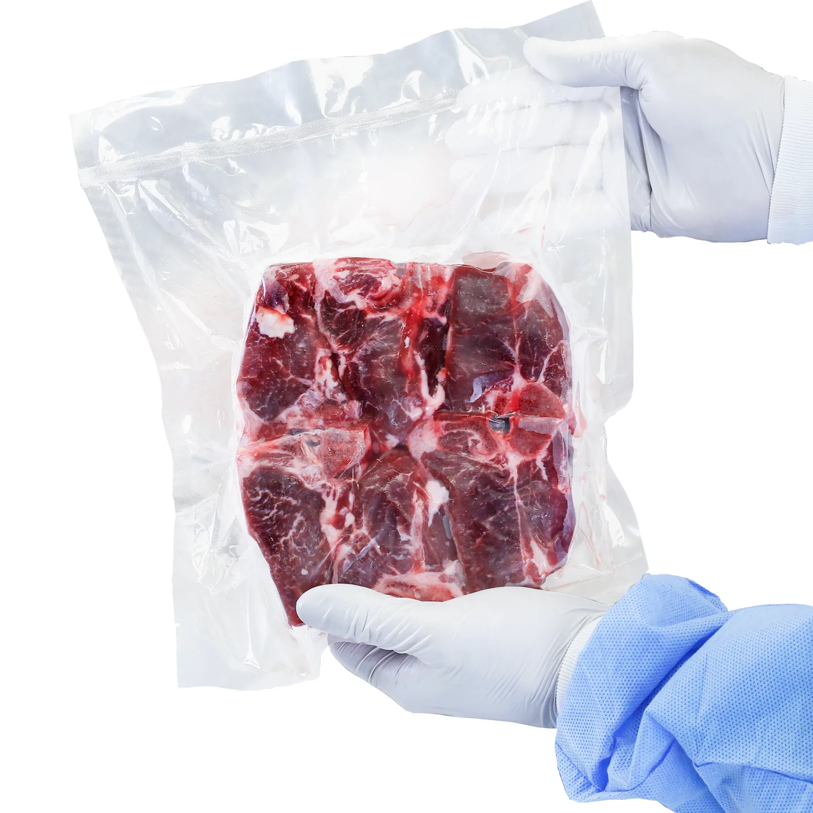 La imagen muestra a una persona sosteniendo una bolsa sellada al vacío con un gran trozo de carne cruda en su interior. La persona lleva ropa desechable.